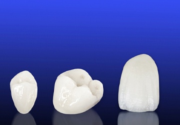 Three dental crowns against a blue background
