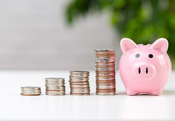 Coins next to a piggy bank