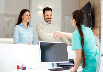 Dental patient shaking hands with dental team member