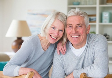 senior man and woman wearing gray cardigans 