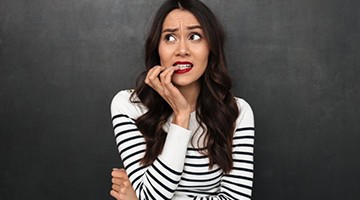 woman nervously biting her fingernails 