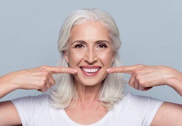 Senior woman pointing to her smile