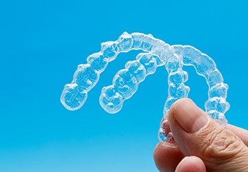 Patient holding up Invisalign clear aligners in Melbourne