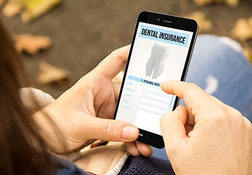 Patient reviewing dental insurance information on phone