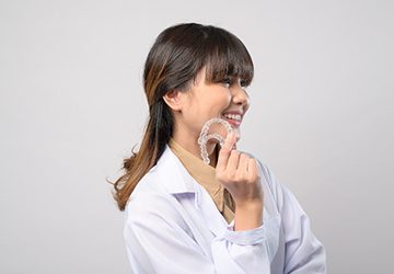 SureSmile dentist in Melbourne holding clear aligners
