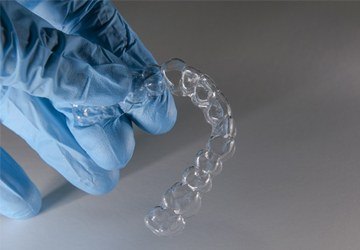 gloved hand holding aligner