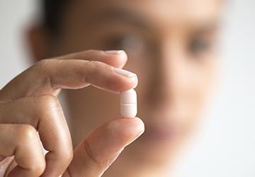Hand holding an antibiotic tablet pill
