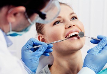 A woman having her teeth looked at by the dentist