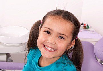 Smiling young girl in dental chair