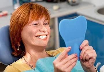 Senior woman looking at smile in mirror