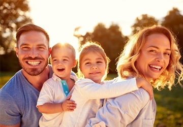 smiling couple with two small children