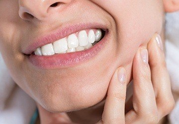 Closeup of patient holding jaw in pain