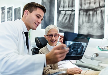 A dentist showing an older patient an X-ray.