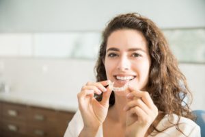 woman holding clear braces