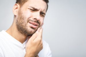 Man in white shirt who needs an emergency dentist in Melbourne