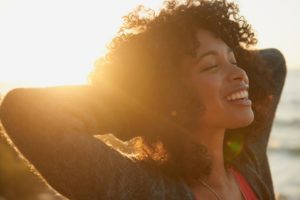 woman smiling in the sunset with porcelain veneers 