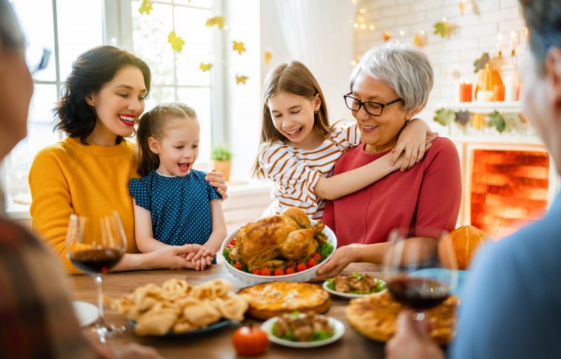 family eating Thanksgiving dinner with dental implants