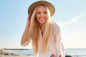 Woman wearing a sun hat and smiling during summertime.