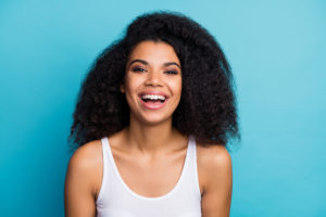 a person smiling against a light blue background